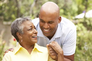 Senior Woman Being Hugged By Adult Son