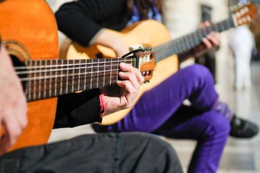 Close up of hands playing a guitar.