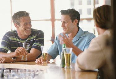 Three men sitting at bar having drinks