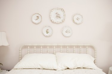 Bedroom with porcelain hanging on wall above bed