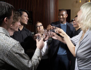 Group of friends toasting in bar, laughing