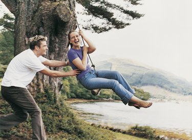 Couple Playing on a Rope Swing, Man Pulling Woman