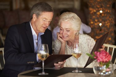 Senior Couple Choosing From Menu In Restaurant