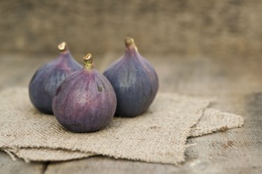 Fresh figs with hessian napkins on wooden background