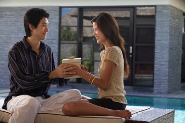 Young couple exchanging gift, side view