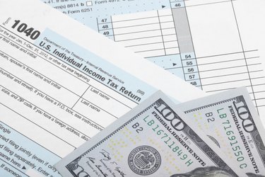 Tax Form 1040 with two 100 dollars banknotes