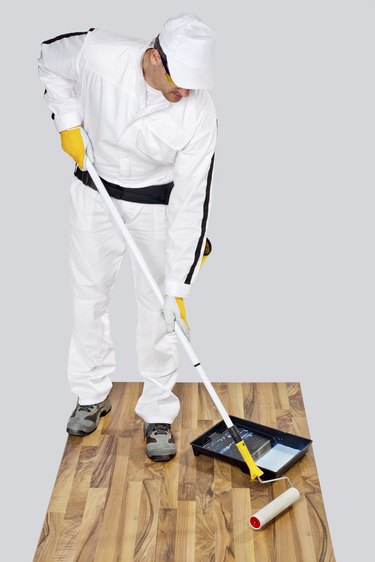 worker paint with primer wooden floor for waterproofing