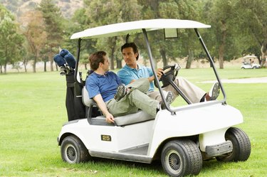 Two men riding in golf cart