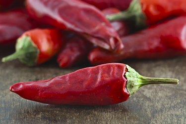 Dried cayenne red pepper on wooden surface selective focus