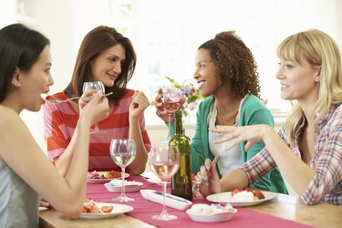 Group Of Women Sitting Around Table Eating Dessert