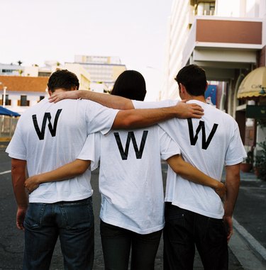 view from behind of three men wearing www on their t-shirts
