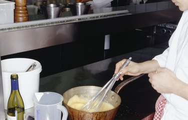 Chef stirring ingredients in pan