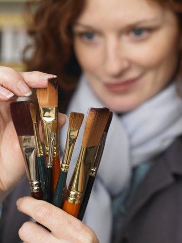 Woman looking at paint brushes, focus on brushes