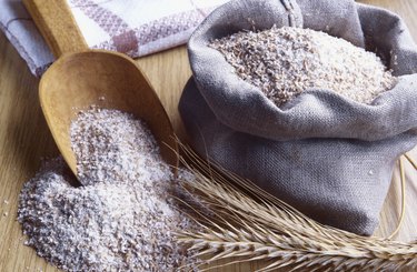 Still life of wheat flour with wooden scoop