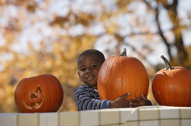 Boy embracing pumpkin