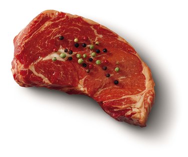 Raw steak with peppercorns