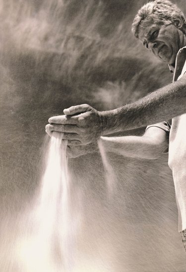 Man running sand through his hands