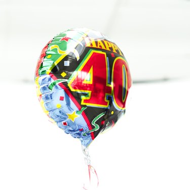 a shiny birthday message helium balloon held up by a thread