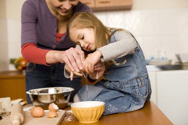 Woman and girl cooking together