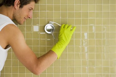 Man cleaning shower handle