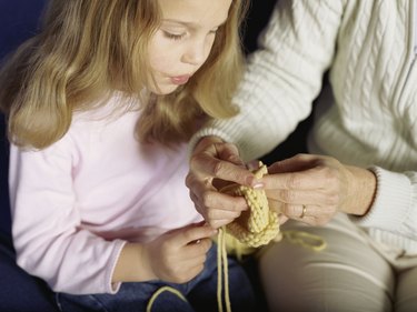 Mother teaching daughter to knit