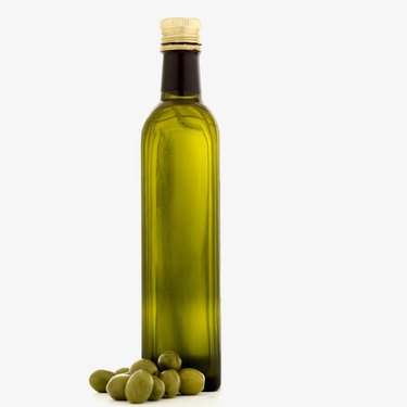 a bottle of olive oil and olives