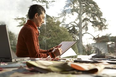 Woman working on pad at desk