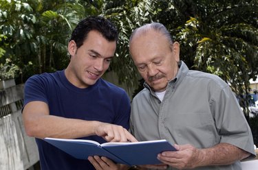 Young man showing a book to a senior citizen