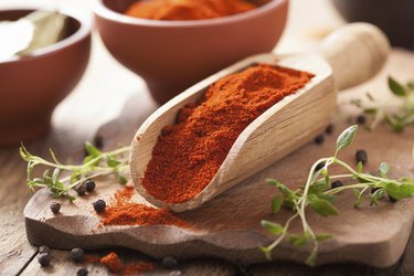 red ground paprika spice in wooden scoop and bowl