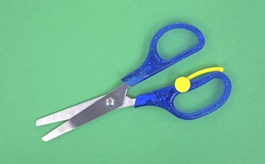 Child's scissors on green craft paper