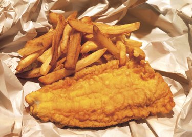 high angle view of fried fish and chips on paper