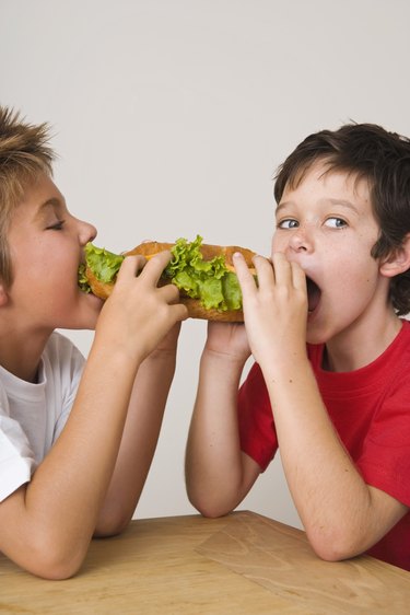 Boys sharing sandwich