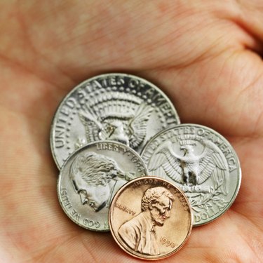 Close-up of a human hand holding various American denominations