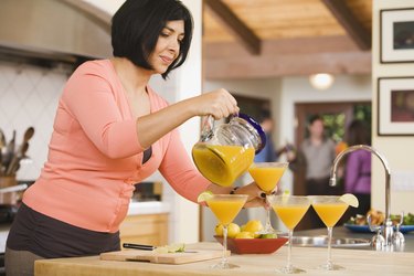 Middle-aged Hispanic woman pouring cocktails