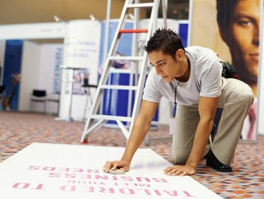 young man wiping a banner