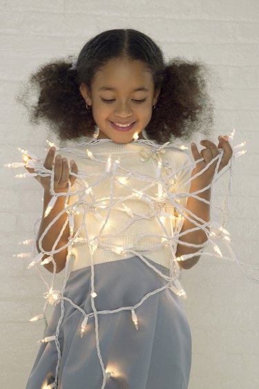 Portrait of a Young Girl Tangled Up in Christmas Lights