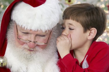 Young Boy Whispers Into Father Christmas' Ear