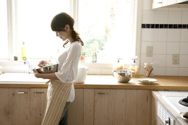 Woman holding mixing bowl in kitchen