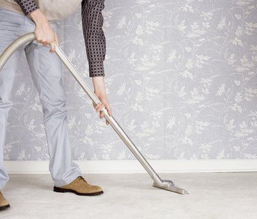 Low Section of a Man Using a Vacuum Cleaner