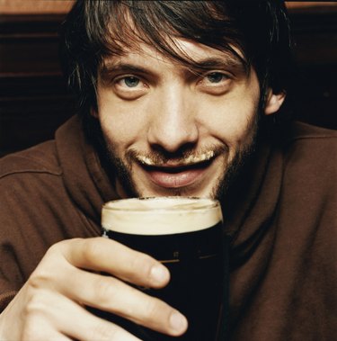 Young Man Enjoying a Drink of Stout in a Pub