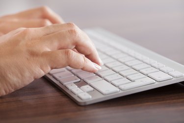 Female Hand Typing On Keyboard