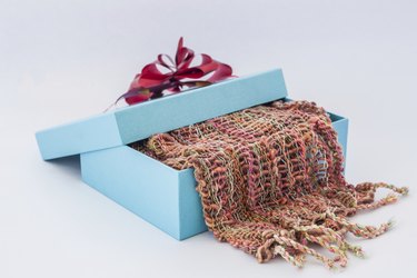 blue gift box with red ribbon and  Striped scarf