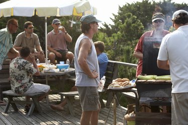 Group of men having barbecue on decking