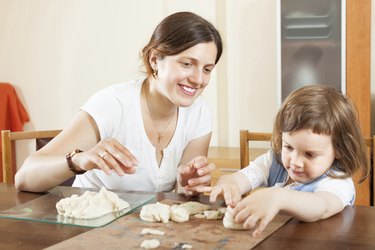 woman and her child sculpting from clay or dough