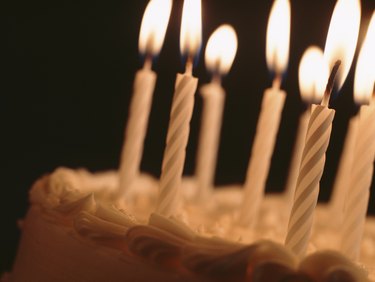 Candles illuminating birthday cake, close-up