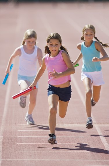 Girls running relay race