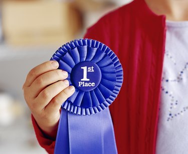 Child holding blue first place ribbon