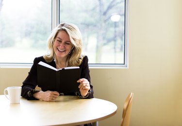 Woman reading book and listening to MP3 player