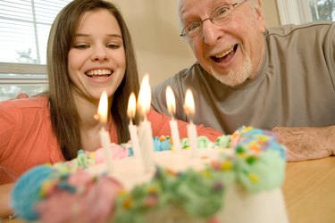 Grandfather and granddaughter with birthday cake