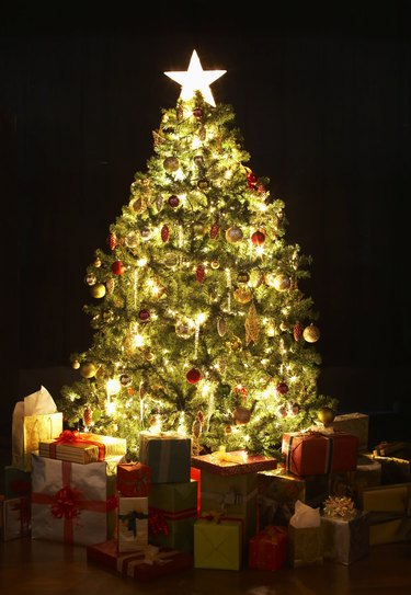 Presents around lit Christmas tree